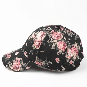 Detail view of pink rose floral print on black fabric baseball cap with curved brim