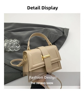 Detail of elegant beige leather handbag with a sleek golden buckle and top handle