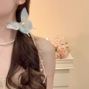 Detail view of fairy butterfly hair clip with long pearl tassels and iridescent resin wings