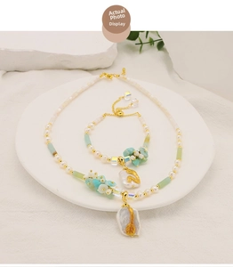 Detail of baroque pearl necklace with amazonite stone and golden leaf pendant design