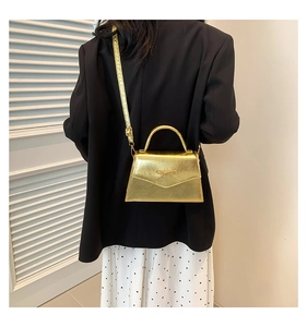 Vue arrière d'un mini sac doré à nœud papillon sur un mannequin en blazer noir et jupe