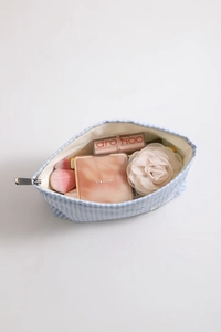 Vue intérieure d'une trousse à maquillage rayée en toile avec produits cosmétiques