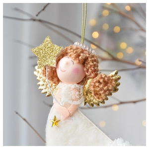 Dettaglio dell'angelo di peluche con ali dorate e stella su un ramo di albero di Natale