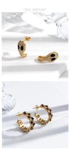 Detailed view of gold C-shaped earrings with inlaid diamonds and black gems on stone