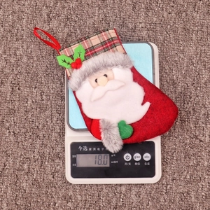 Détail d'une chaussette de Noël en feutre rouge avec Père Noël et bordure à carreaux