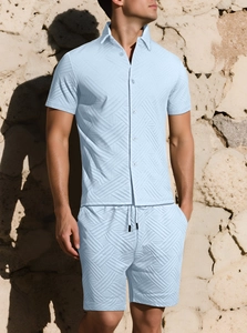 Dettaglio completo di camicia a maniche corte e pantaloncini azzurri con trama a rilievo
