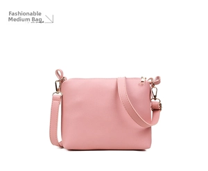 Detailed shot of pink PU leather shoulder bag with golden zippers and adjustable strap