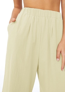 Vue détaillée de la taille élastique et des poches latérales sur ce pantalon large beige