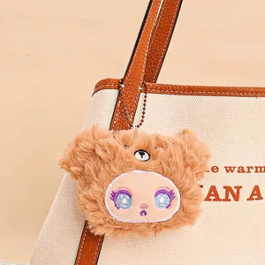 Brown plush cartoon elf animal keychain charm on beige canvas and leather tote bag