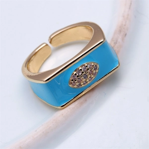 Macro shot of gold-plated copper ring with blue enamel inlay and pink zircon stones