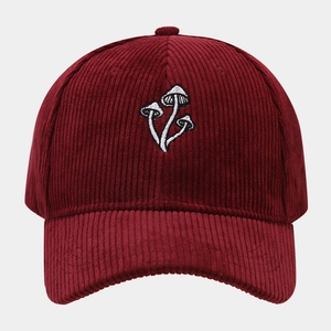 Close-up of three mushroom embroidery on burgundy corduroy baseball cap texture