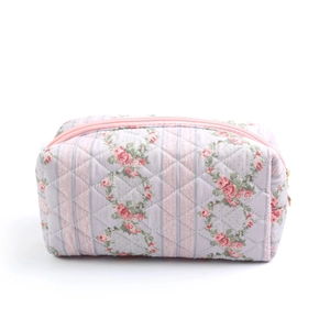 Close-up of pink floral quilted makeup bag with soft fabric and durable zipper detail