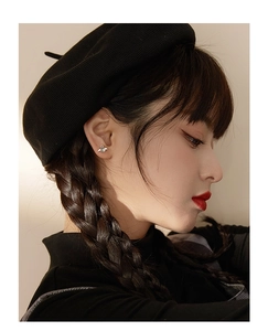 Close-up of minimalist silver bee earrings with grey pearls on model's ear