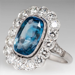 Luxurious cocktail ring with cushion-cut blue gemstone and pavé diamonds in silver setting