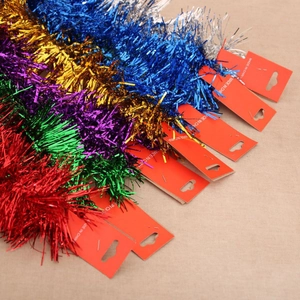 Detail of colorful metallic Christmas tinsel garlands in red, gold, purple, and blue hues