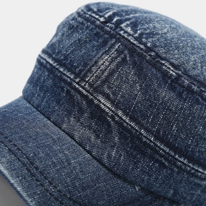 Detail van versterkte stiksels en gewassen denim textuur op de vintage legerpet