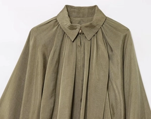 Détail de chemise en popeline vert olive avec col pointu, fermeture éclair et manches bouffantes