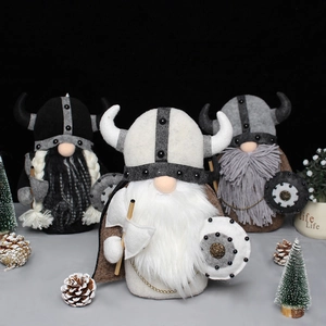 Three standing Viking gnome dolls with horned helmets, axes, and shields on a festive table