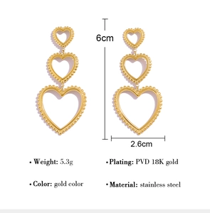 Detailed view of triple tiered gold heart drop earrings with pearl texture and dimensions
