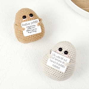 Nahaufnahme von handgehäkelten Kartoffelpuppen in Braun und Beige mit Motivationskarten