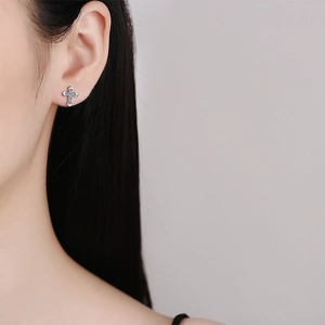 Elegant S925 sterling silver cross stud earrings with blue moissanite on ear lobe