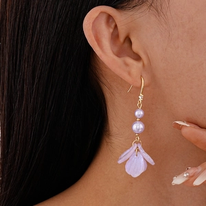 Detail of light purple acrylic petal earrings with pearl fringe on a model for a sweet look