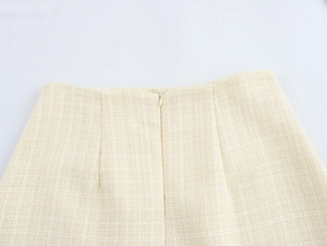Gros plan d'une jupe en tweed beige avec fermeture éclair invisible et tissage