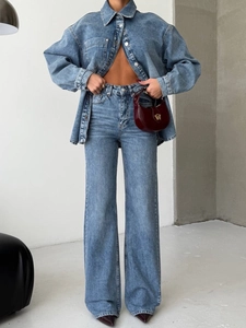 Détail du tissu en jean bleu délavé de la chemise et du jean taille haute sur un mannequin