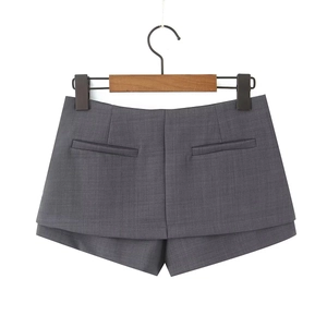 Dettaglio della trama del tessuto grigio scuro della gonna pantalone con spacco frontale
