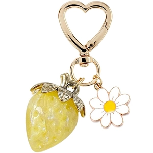 Close-up of yellow strawberry and white daisy pendant with gold heart-shaped keychain
