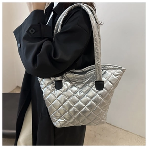 Détail d'un sac cabas argenté métallisé avec surpiqûres losanges porté par un mannequin