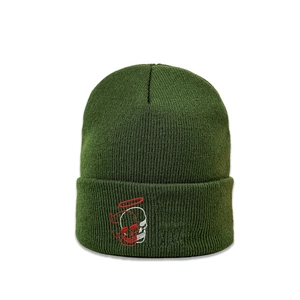 Detailed close-up of dark green beanie showing fine ribbed knit and dual skull embroidery