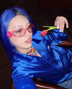 Close-up of pink Y2K heart sunglasses with floral accents worn by a female model