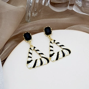 Detail of geometric triangle earrings with black square stone and zebra enamel pattern