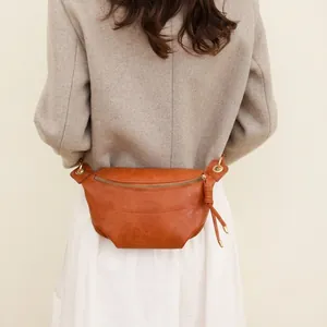 Vue détaillée d'un sac ceinture en cuir marron vintage avec fermetures éclair dorées