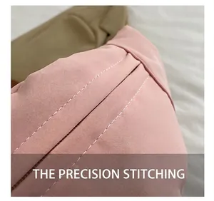 Detailed close-up of white precision stitching on a pink fabric dumpling bag