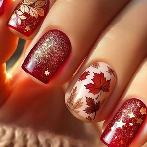 Autumn-themed press-on nails featuring glitter red stars and rustic maple leaf patterns