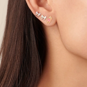 Close-up of S925 silver stud earrings featuring white bows and a pink robot design