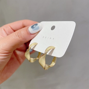 Fashionable twisted golden geometric hoop earrings with polished glossy finish