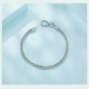 Detail showing S925 hallmark on a silver infinity chain bracelet with woven texture