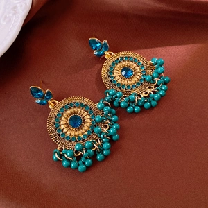 Detail view of vintage Jhumka earrings with blue rhinestones and turquoise beaded tassels