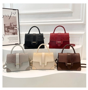 Details verschiedener farbiger Handtaschen mit Krokodilmuster auf weißem Display