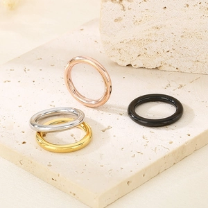 Minimalist 18k gold plated titanium rings in four colors on a textured stone base