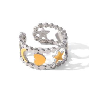 Detail of adjustable silver ring featuring hollow star, moon and heart patterns with yellow enamel