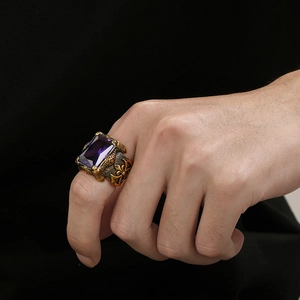 Detail of gothic stainless steel ring with square purple gem and ornate vine carving