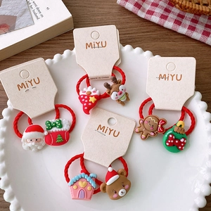 Close-up of festive red Christmas hair ties with 3D Santa and reindeer cartoon charms