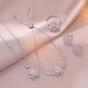 Silver jewelry set with pink flower zircons on silk including necklace, ring and earrings