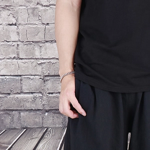 Close-up of minimalist silver titanium steel chain bracelet worn on a model's wrist