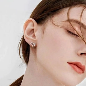 Elegant silver bow earrings with crystals on female model for a minimalist chic look