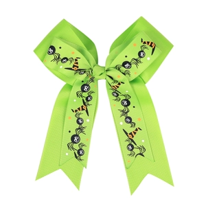 Detail of Halloween hair clip with green grosgrain ribbon featuring spider and witch hat patterns